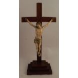 An Antique German carved ivory crucifix, on a later mahogany cross, with stopped base, label to base