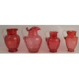 Four various ruby glass jugs, with clear glass handles, heights 7.5ins and down