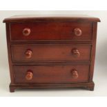 A miniature chest, of three long drawers, raised on bracket feet, width 8.5ins x height 7.5ins