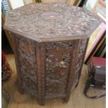 A carved Eastern octagonal table, with folding base, diameter 24ins, height 25ins