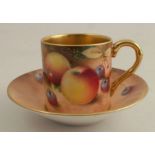 A Royal Worcester coffee can and saucer, painted with fruit to a mossy background by Roberts -