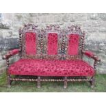 A triple chair back settee, in the Jacobean style, the oak frame carved with trailing vine and