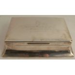 A silver cigarette box, of rectangular form, with presentation inscription to the lid from the