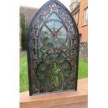 A 19th century stained glass panel, of arched form, depicting a saint, on an oak base, size