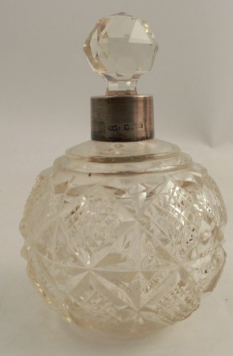 A glass dressing table bottle, with hallmarked silver collar and cut decoration to the body
