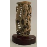 A Chinese carved and pierced soapstone candlestick, formed as an immortal seated on a dragon,