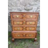 An 18th century design small oak chest on stand, with three drawers, having inlaid and cross