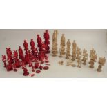 A 19th century Oriental carved ivory chess set, with white and stained red pieces, carved as