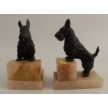 A pair of Scottie dog painted spelter bookends, raised on onyx bases, height 6.25ins