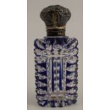 A carved over laid blue glass scent bottle, with white metal cap, height 3.5ins