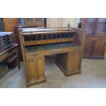 An oak Gothic style cylinder bureau, the cylinder revealing a ratcheted writing slope, with