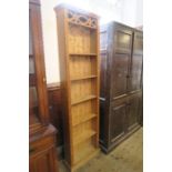 A pine bookshelf, with plank back, and five shelves below a lattice frieze, width 22ins x depth 6.