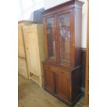 A late 19th century walnut bookcase cupboard, having two glazed doors over a drawer, with two