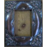 An Art Nouveau copper mounted photograph frame, decorated with leaves, having a hammered finish,