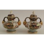 A pair of Crown Derby covered urns, decorated with flowers and panels of birds to front and back,