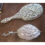 A white metal hair clip, with embossed decoration together with a dolls hand mirror, with embossed