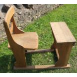 An child's oak desk joined to a chair