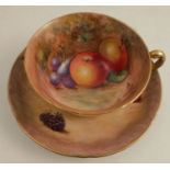 A Royal Worcester tea cup and saucer, decorated with hand painted fruit by Cook and Smith, the cup