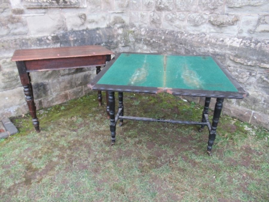 An ebonised fold over card table, of rectangular form, raised on four turned legs united by