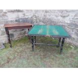 An ebonised fold over card table, of rectangular form, raised on four turned legs united by