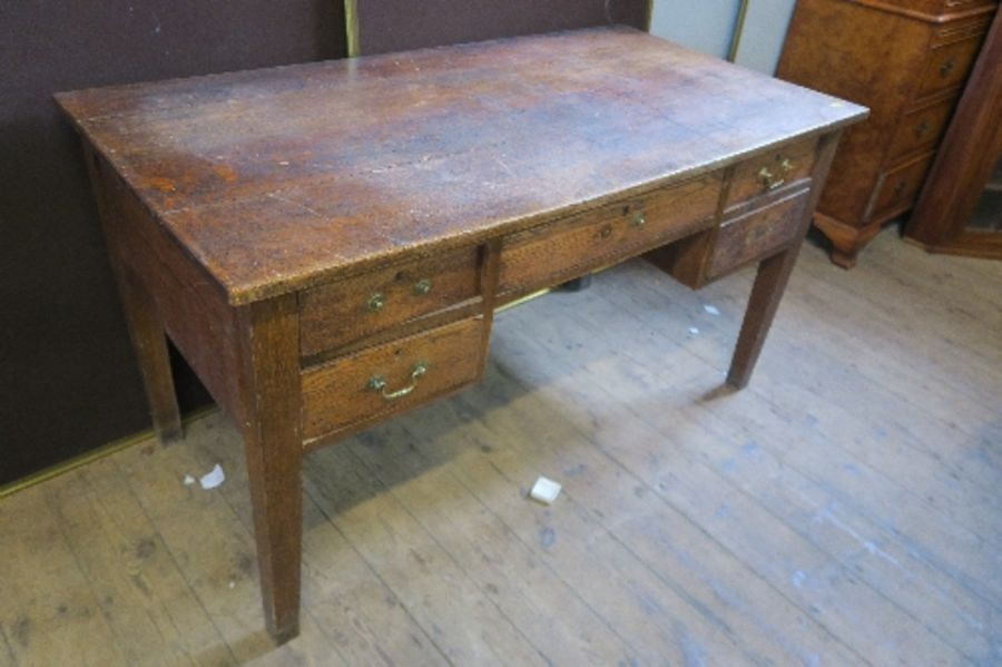 An early 20th century oak desk of rectangular form, fitted with one central drawer above a kneehole,