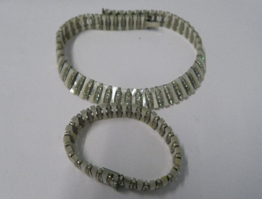 A paste and faux mother of pearl necklace and bracelet, together with pair of clip earrings, cased