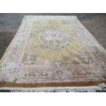 A large Chinese wool wash rug, with floral decoration to a mustard ground, 166ins x 121ins