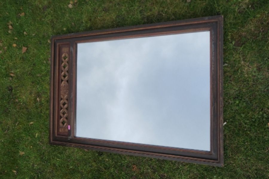 An Eastern design  mirror, with carved fret decoration to the top, 31ins x 23ins