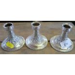 Three Indian silver dwarf candlesticks, highly decorated, height 3.25ins