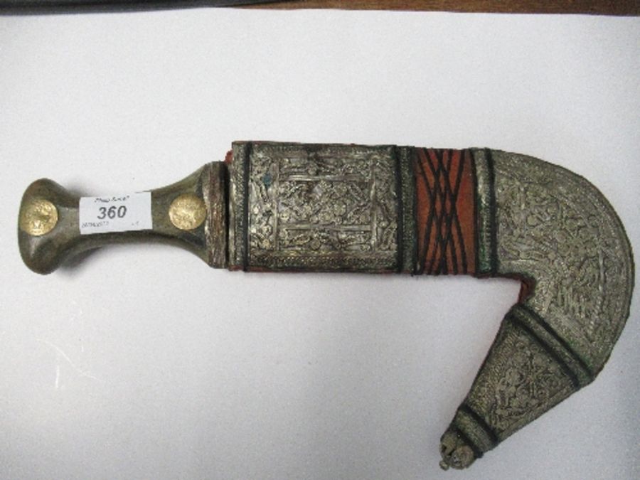 An Arabic Jambiya dagger, with horn handle inset with coins, and white metal scabbard