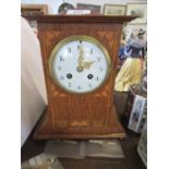 An Art Nouveau style oak inlaid mantle clock, with circular enamel dial