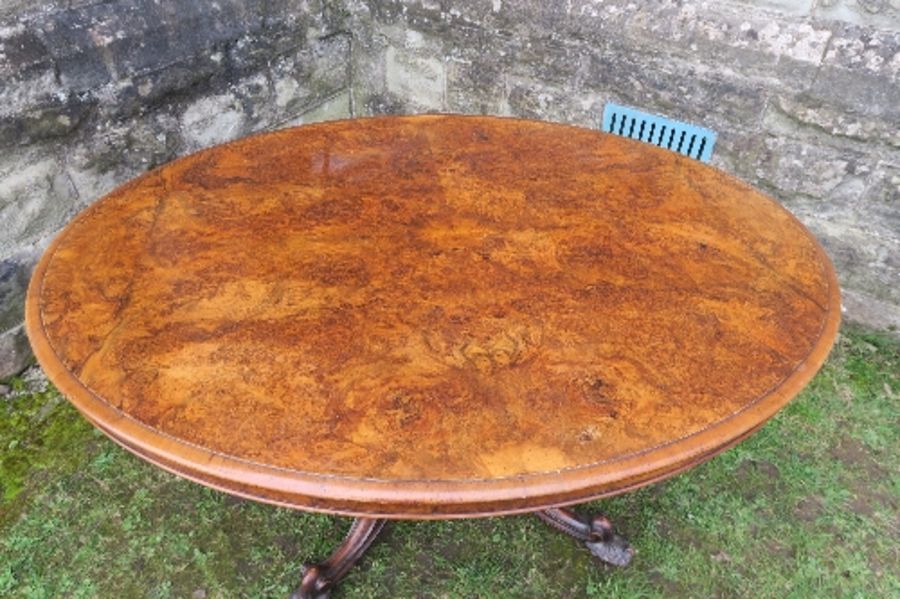 A 19th century burr walnut oval loo table, raised on a turned column, terminating in four outswept - Image 2 of 5