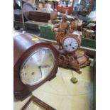 A 19th century style mantle clock flanked by a figure, together with another