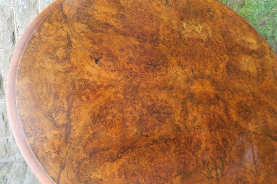 A 19th century burr walnut oval loo table, raised on a turned column, terminating in four outswept - Image 5 of 5