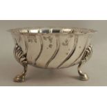A silver bowl with shaped edge, raised on three scroll legs with hoof feet, London 1909, weight 6oz,