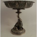 An Indian white metal tazza, the bowl heavily embossed with Deity, the pedestal formed as an