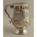 A silver mug, with embossed decoration to the baluster body, raised on a circular foot, London 1890,