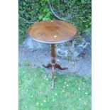 A circular mahogany occasional table, raised on a turned column, terminating in a tripod base,