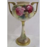 A Royal Worcester vase, raised on a pedestal, decorated with roses to gilt lug handles, shape number