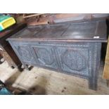 An 18th century oak coffer, having three carved panels to the front, with three plain panels to