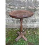 An antique primitive style lamp table, with oak top, raised on a turned walnut column with cruciform