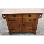 An Arts and Craft oak sideboard, with flyover top supported by pierced brackets, and having copper