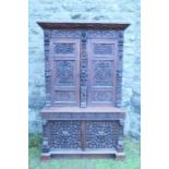 A late 19th century oak panel cupboard, having two acorn escutcheons, two carved and panelled doors,