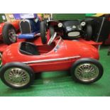 A red Ferrari swing pedal car, with solid rubber tyres, approx. 48” x 27”