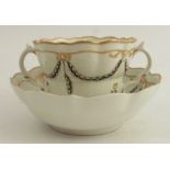 A 19th century English porcelain two handled cup and saucer, decorated with swags and flowers -
