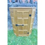 An oak panelled corner cupboard, by Robert Mouseman Thompson of Kilburn, with canted corners,