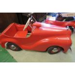 A red swing pedal car, having solid rubber tyres, 50” x 18”