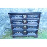 An antique oak chest, of four graduated drawers with moulded fronts, and raised on bracket feet