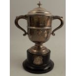 A silver covered two handled cup, with ribbed body, raised on a pedestal foot, Sheffield 1922,