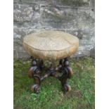 A 19th century circular stool, raised on four turned supports, united by a turned cross stretcher,